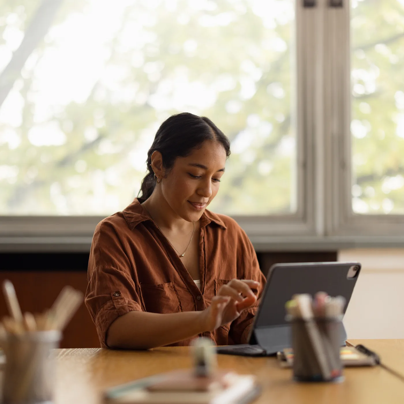A person at a desk working on a tablet